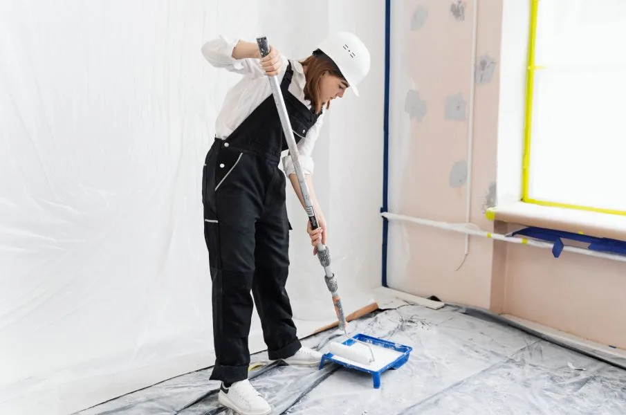Professional painter applying interior coatings in a commercial space.