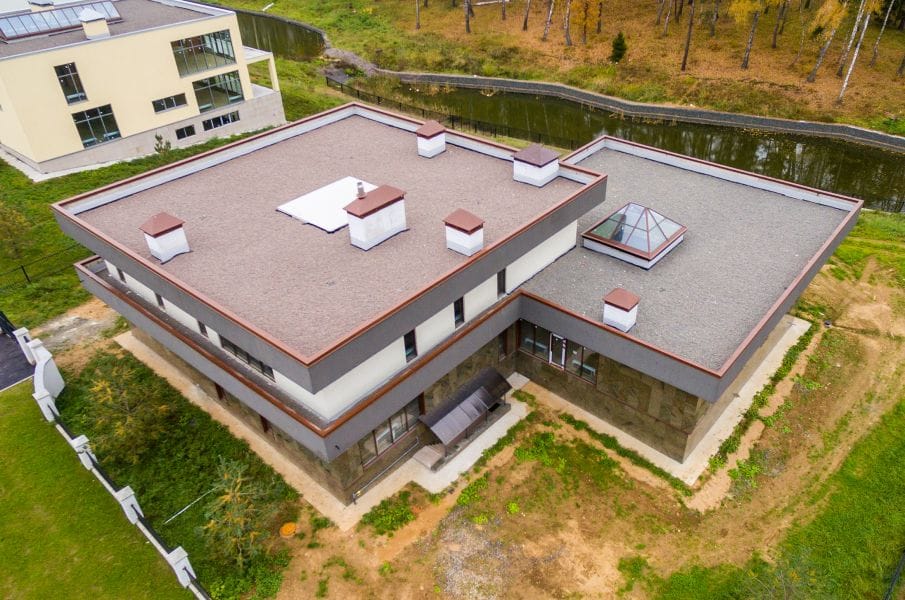 Commercial flat-roof membrane installation with insulation and rooftop details.