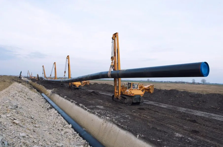 Underground utility trench with water, sewer, and storm piping installation.