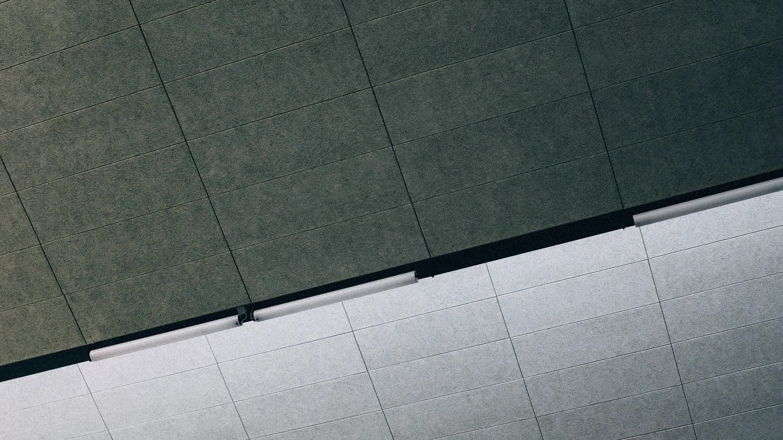 Commercial interior ceiling with modular acoustical panels, lighting, and ventilation components.