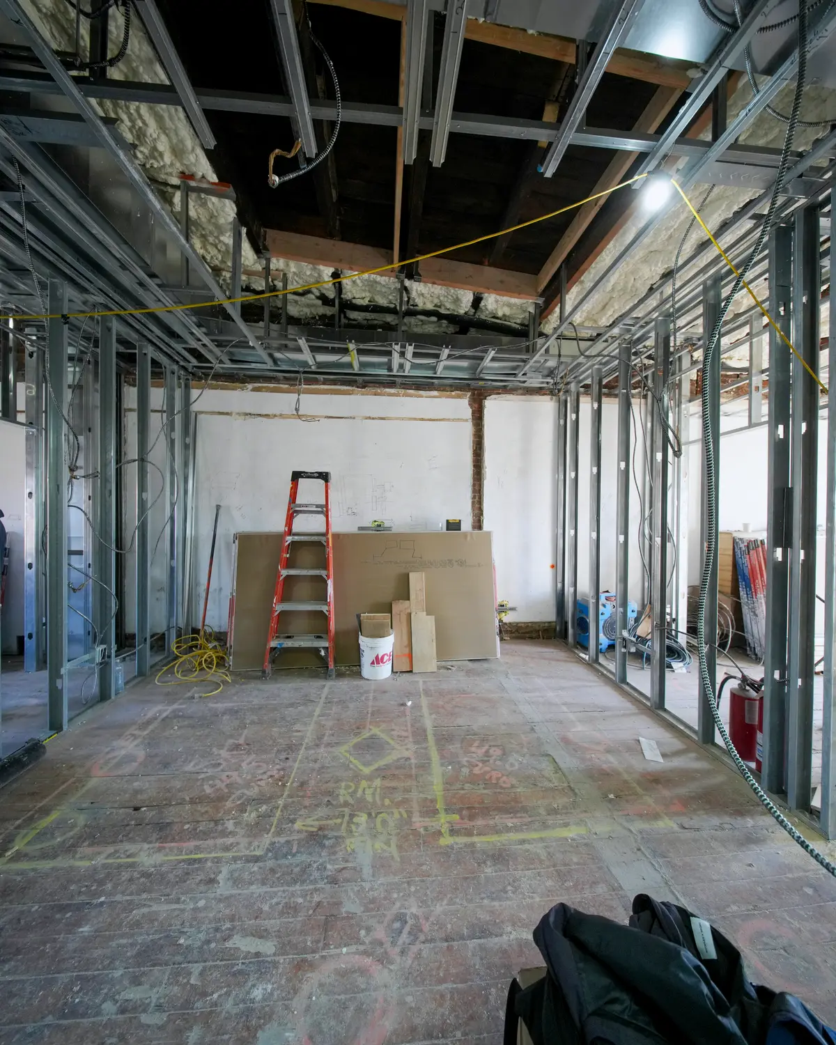 Installer assembling suspended acoustical ceiling grid in a commercial interior