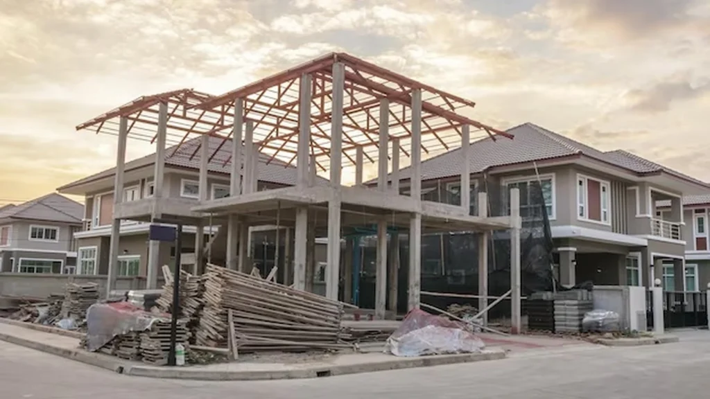 Custom home under construction with exposed structural framing and exterior building work.