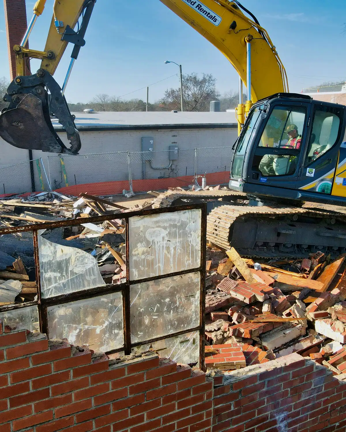 Controlled demolition work on a commercial building with active removal equipment