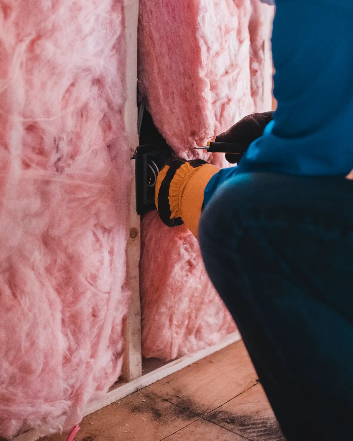 Installer applying insulation and waterproofing materials to a commercial building envelope