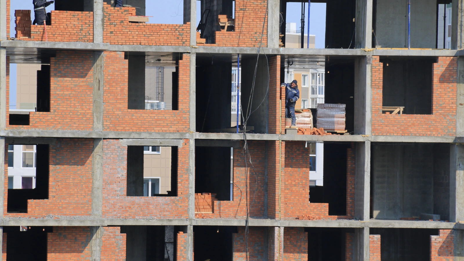 Multistory construction project with brick masonry infill walls between concrete structural frames.