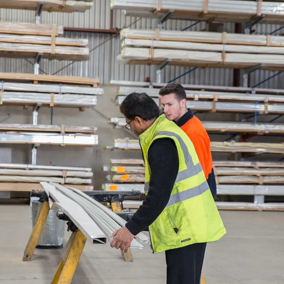 Construction professionals reviewing materials in a building supply warehouse