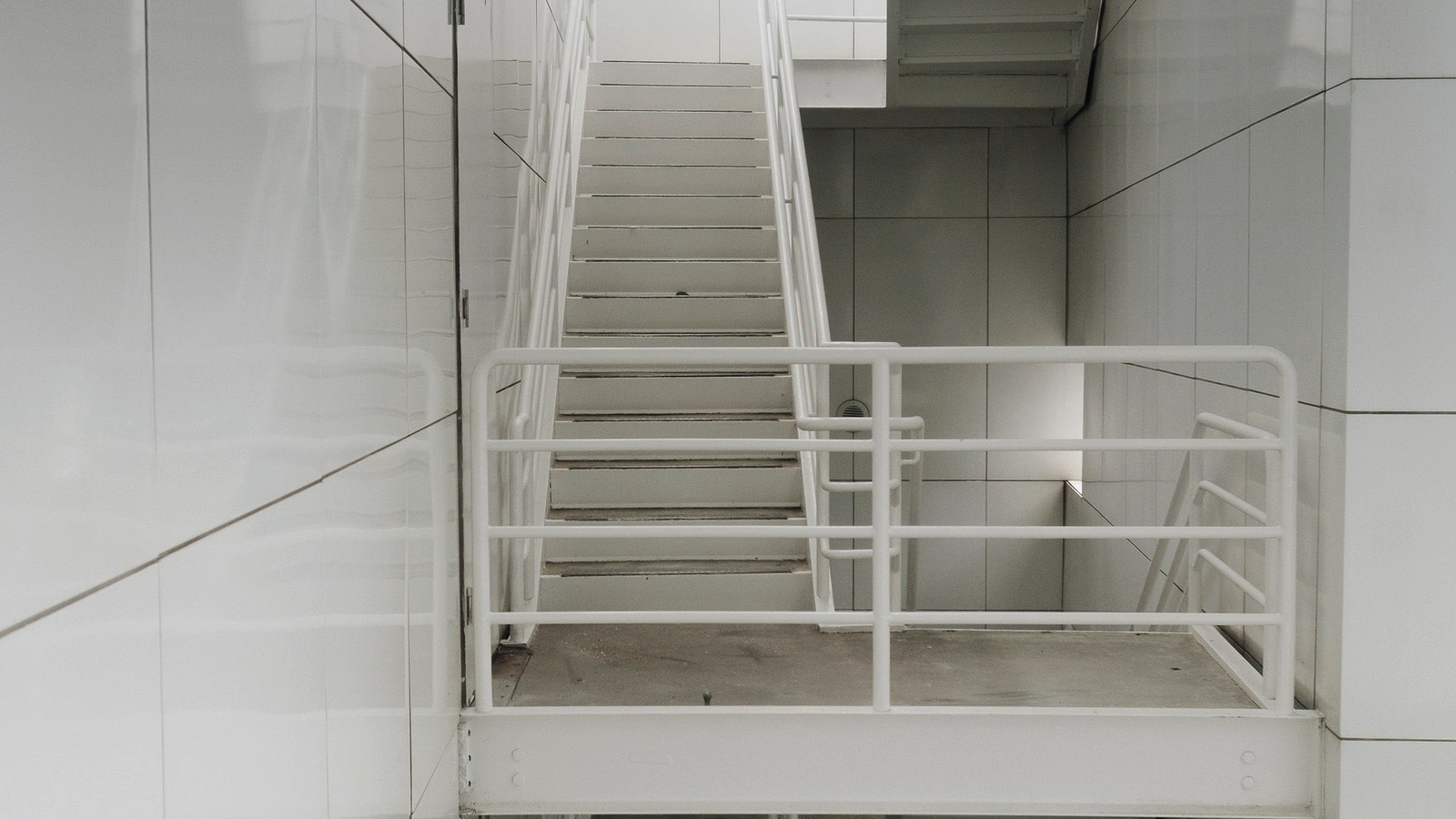 Commercial metal staircase with fabricated handrails, guardrails, and structural steel components.