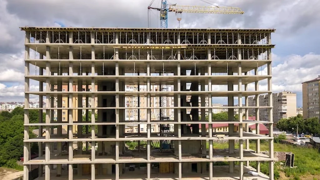 Multifamily apartment building under construction with repeated floors and structural framing.