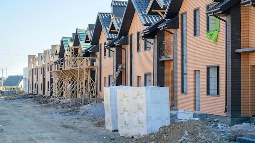 Townhome community under construction with attached repeated units and varied front elevations.