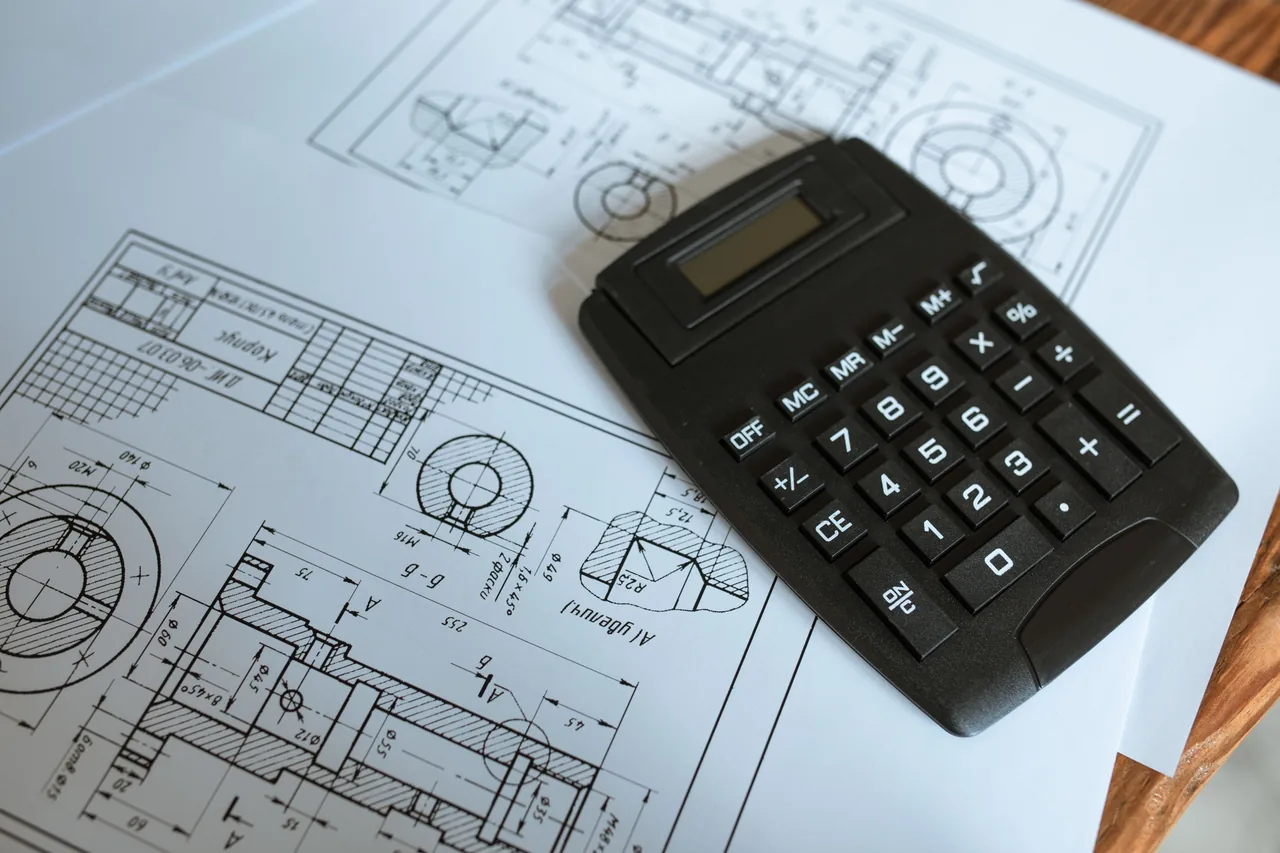 Calculator resting on construction blueprints during construction estimate review