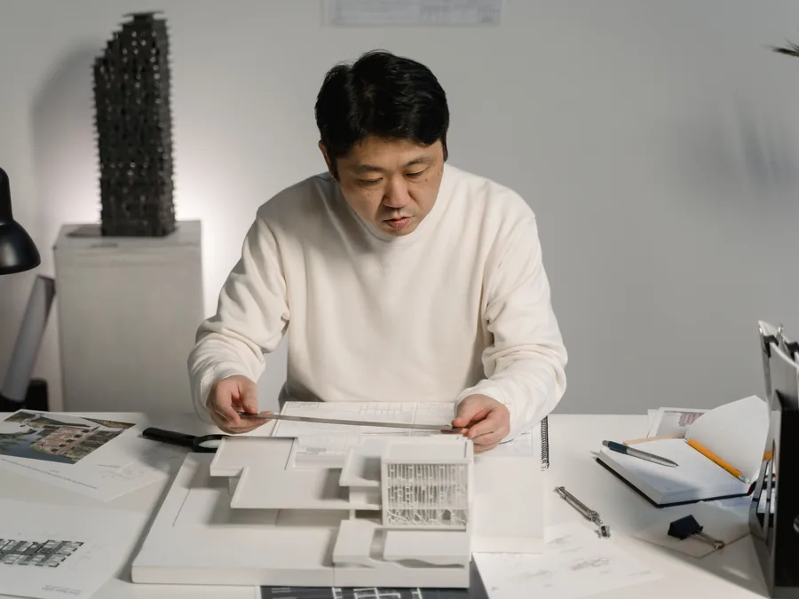 Design professional reviewing blueprints and an architectural model during early project planning