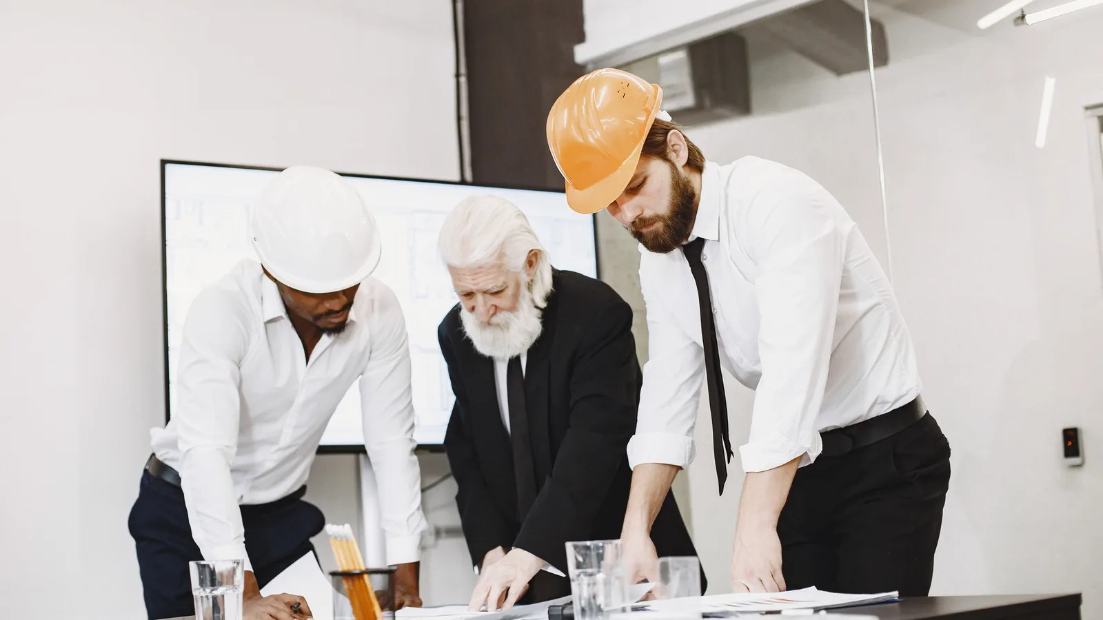 Construction professionals reviewing blueprints for quantity takeoff, material takeoff, and cost estimating decisions